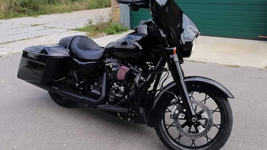 Zwarte Harley-Davidson met diepe glans voor een groene garagedeur