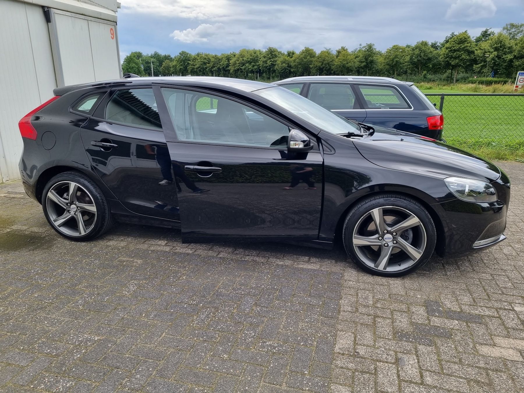 Zwarte Volvo V40 met open portier, glanzend na de behandeling